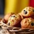 Een mand vol heerlijke muffins met een Belgische vlag op de achtergrond