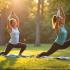 Twee vrouwen doen yoga in een park